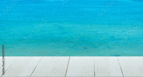 Beautiful wooden floor and blue background, sea water and sky.