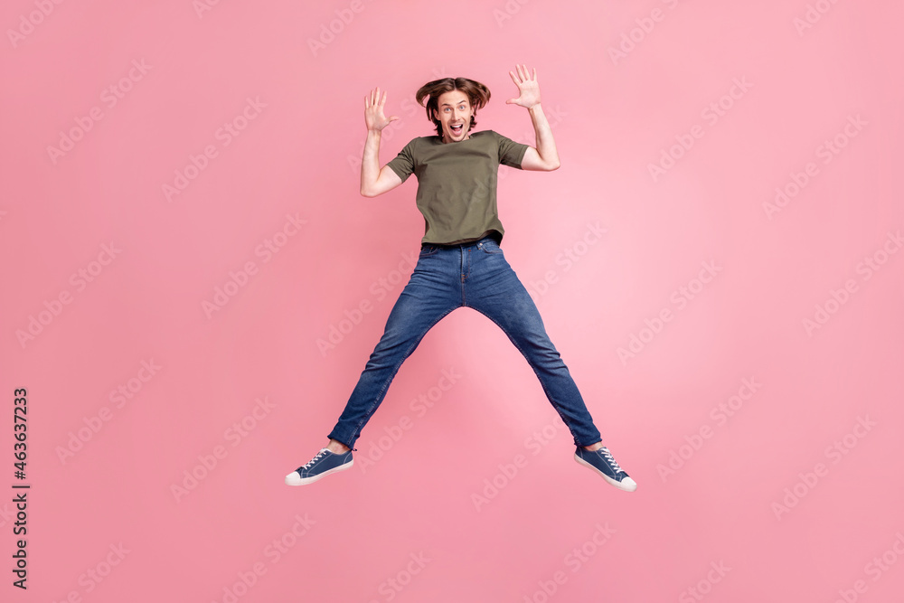 Full body photo of young cheerful man jump fly casual outfit wave hello isolated over pink color background Full body photo of young cheerful man jump fly casual outfit wave hello isolated over pink color background
