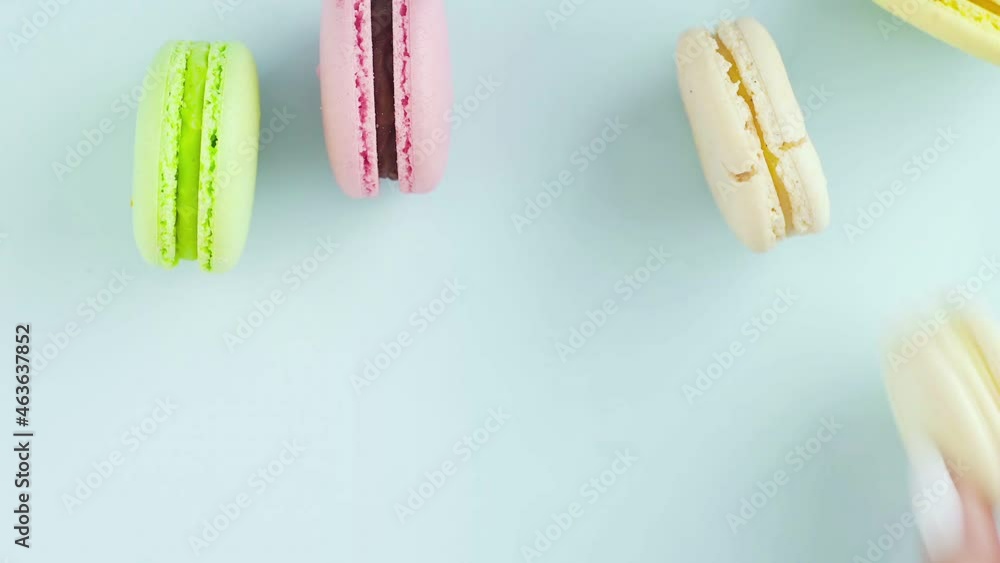 Top view of multicolored French Macarons cookies on a pastel blue background Top view of multicolored French Macarons cookies on a pastel blue background