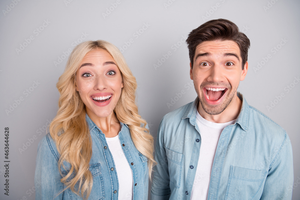 Photo of young cheerful couple happy positive smile excited wow glad isolated over grey color background Photo of young cheerful couple happy positive smile excited wow glad isolated over grey color background