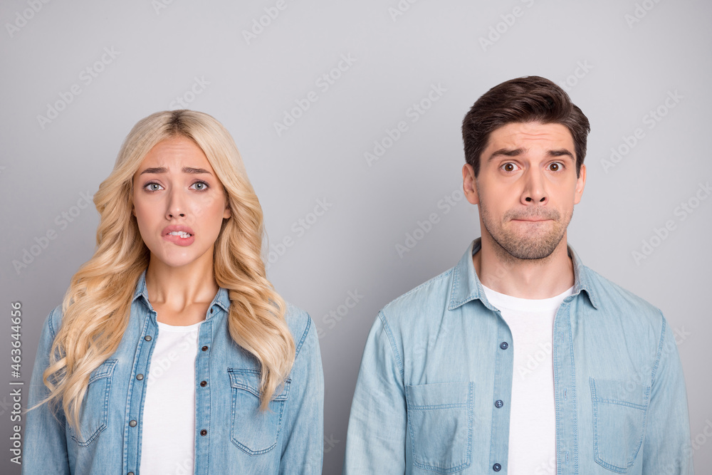 Photo of young couple worried nervous bite lips teeth fail problem anxious isolated over grey color background Photo of young couple worried nervous bite lips teeth fail problem anxious isolated over grey color background