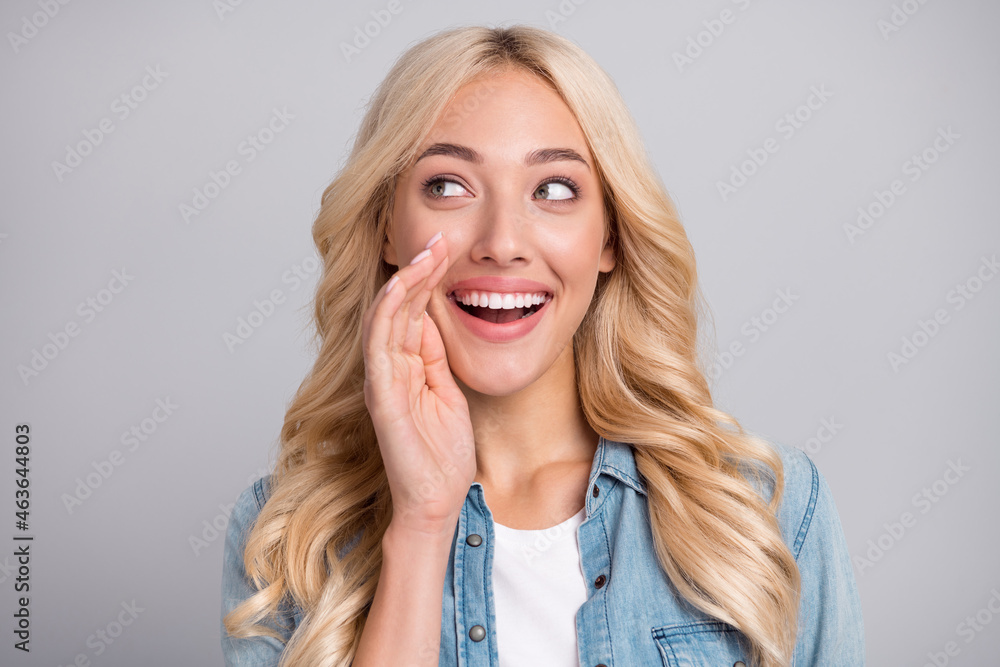 Photo of young girl happy positive smile hand near mouth speak whisper news gossip announcement isolated over grey color background Photo of young girl happy positive smile hand near mouth speak whisper news gossip announcement isolated over grey color background