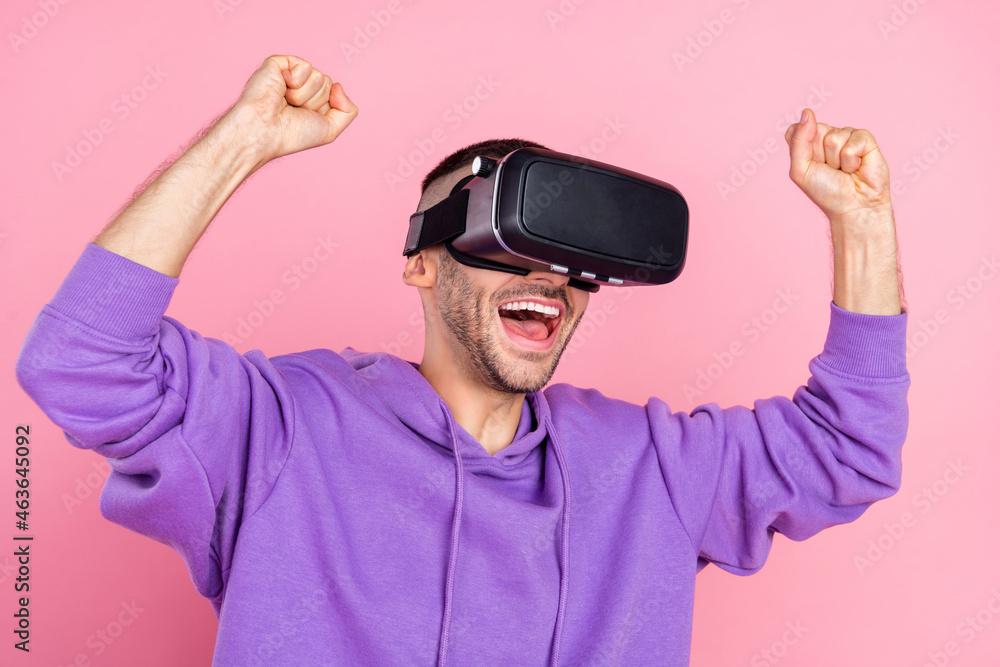 Photo of young cheerful guy have fun celebrate victory win game goggles isolated over pink color background Photo of young cheerful guy have fun celebrate victory win game goggles isolated over pink color background