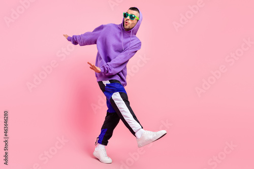 Full size photo of crazy millennial brunet guy dance wear eyewear hoodie pants shoes isolated on pink background