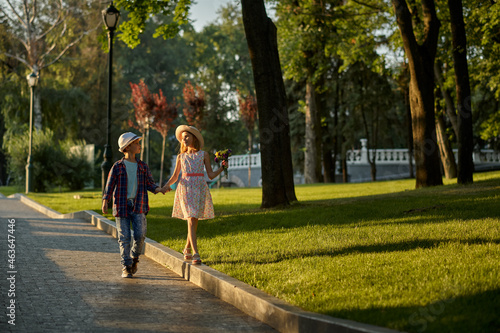 Fototapeta Naklejka Na Ścianę i Meble -  Children's date, boy and girl on walk path in park