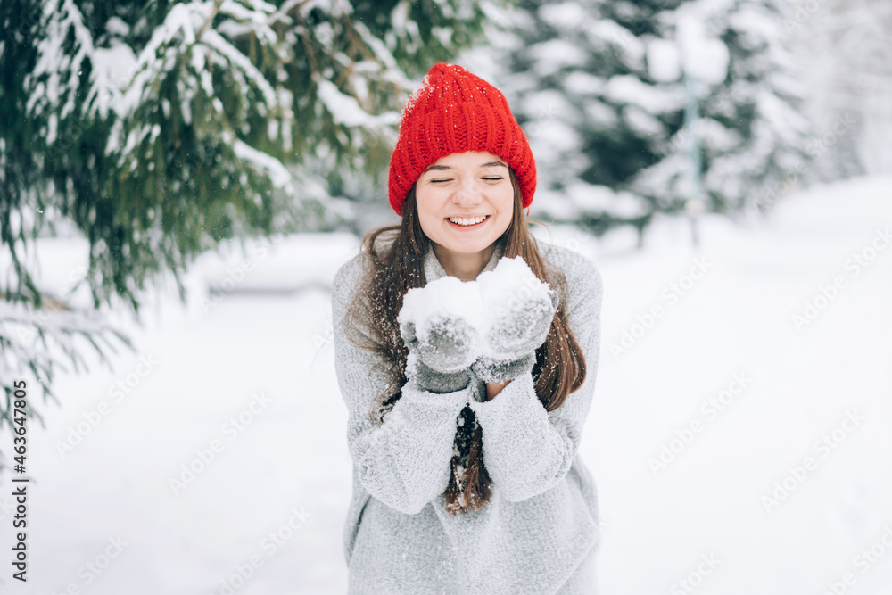 Girl in red hat holding snow in her hands. Girl in red hat holding snow in her hands.
