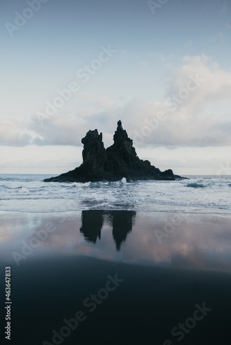 Early morning on the Playa Benijo on the north of Tenerife, Canary islands, dramatic scenery with volcanic black sand beach and sharp cliffs in the Atlantic ocean, reflection of the rock