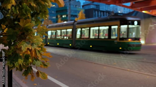 Modern Tram is moving under the pedestrian bridge in the Jatkasaari neighborhood. Modern European Nordic Architecture.