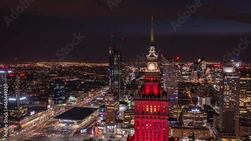 Slide and pan footage of night cityscape. Hyperlapse shot of red illuminated historic high rise Palace of Culture and Science. Warsaw, Poland photo
