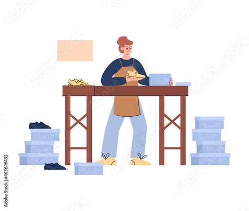 Male shoemaker in shoe workshop is packing new pair of shoes into boxes