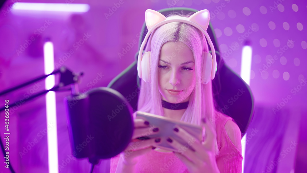 Portrait of cute Gamer Girl with microphone streaming playing on smartphone Portrait of cute Gamer Girl with microphone streaming playing on smartphone