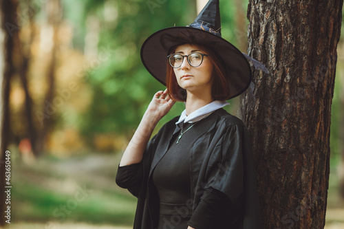 Obraz na płótnie Halloween Witch. Portrait of a girl in a hat and a witch costume in the forest. Ready for trick or treat holiday
w salonie