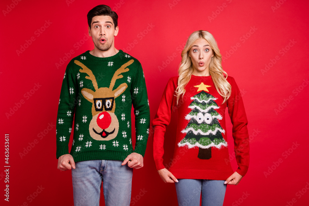 Photo of amazed shocked funny couple show print open mouth wear ugly ornament sweater isolated red color background