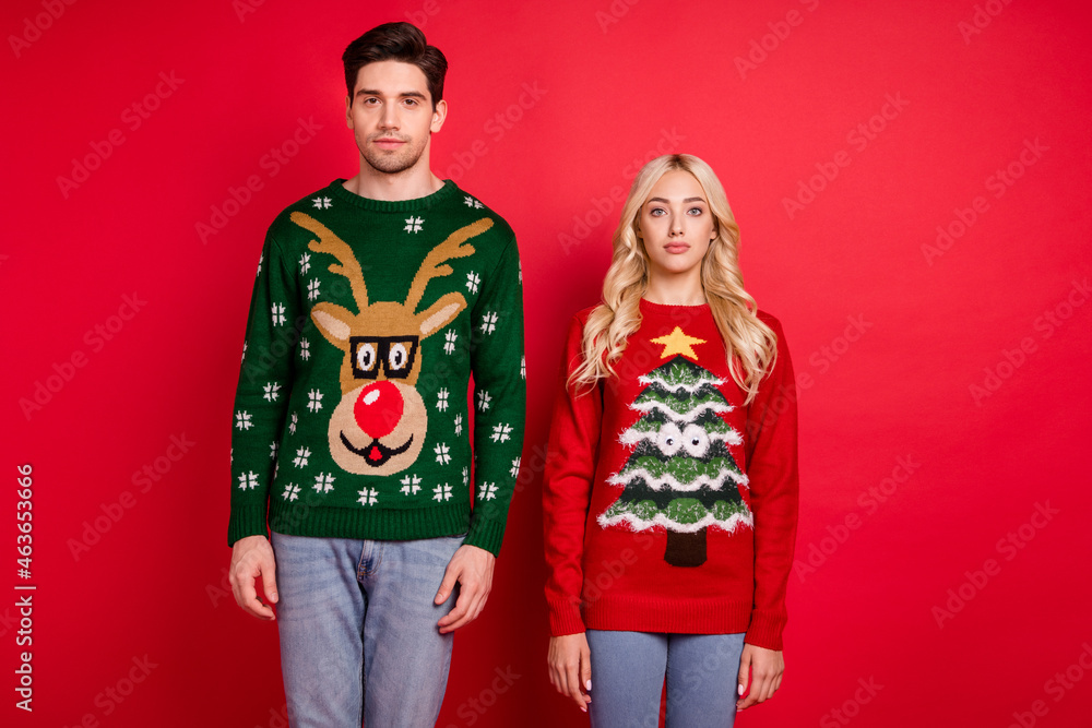 Photo of nice x-mas couple boyfriend girlfriend wear ugly ornament sweater isolated red color background Photo of nice x-mas couple boyfriend girlfriend wear ugly ornament sweater isolated red color background
