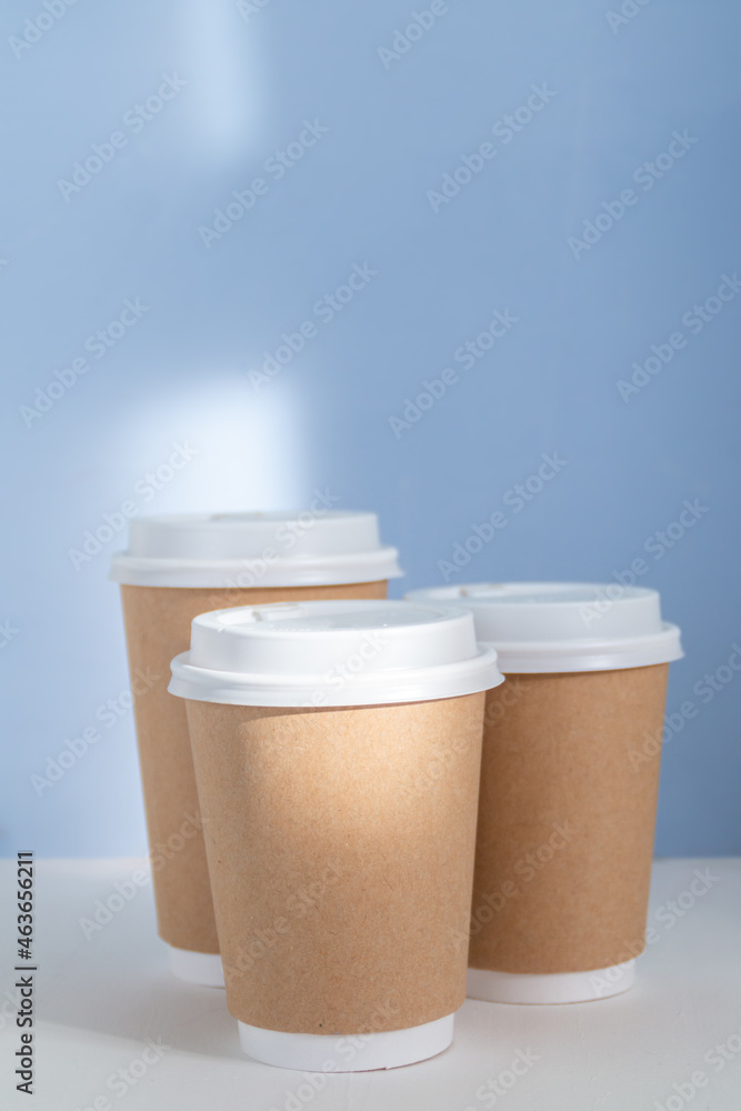 empty paper cup to go against light blue background empty paper cup to go against light blue background
