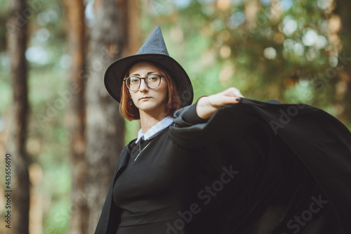 Obraz na płótnie Halloween Witch. Portrait of a girl in a hat and a witch costume in the forest. Ready for trick or treat holiday
w salonie