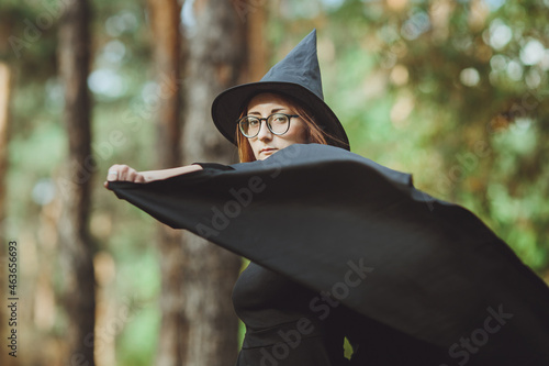 Obraz na płótnie Halloween Witch. Portrait of a girl in a hat and a witch costume in the forest. Ready for trick or treat holiday
w salonie
