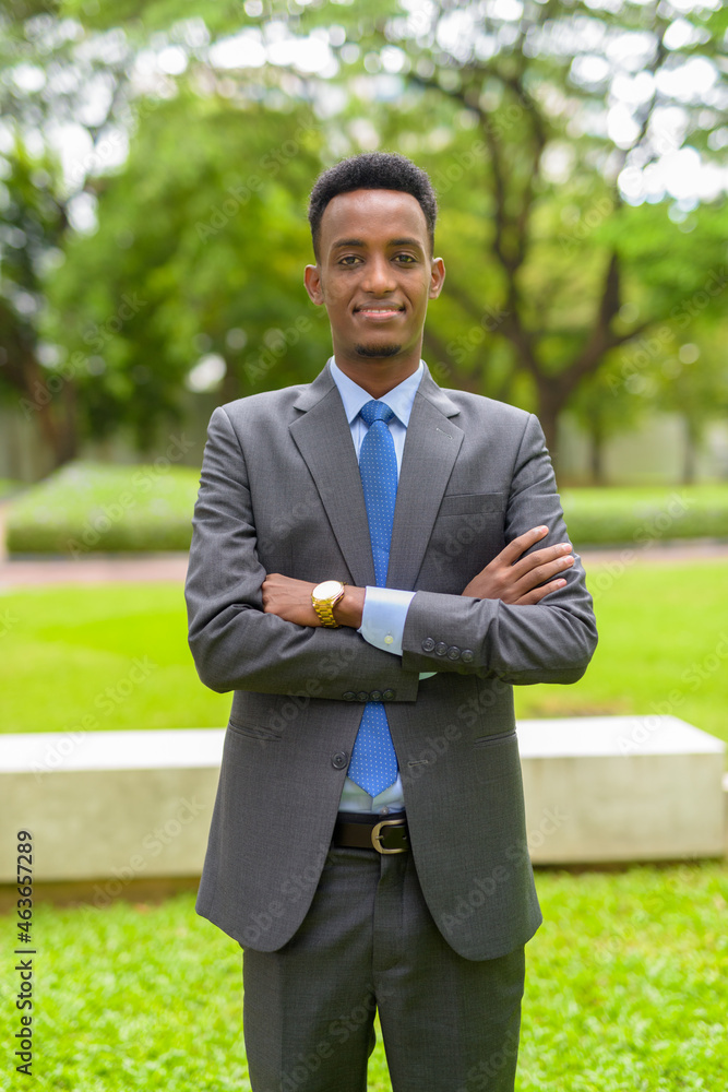 Portrait of handsome African businessman wearing suit and tie at park outdoors Portrait of handsome African businessman wearing suit and tie at park outdoors
