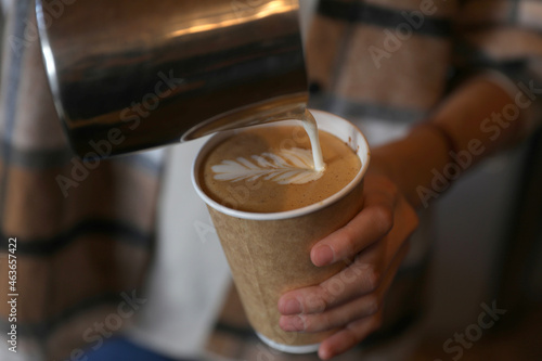 Barista girl making coffee in paper cup