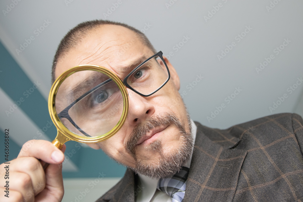 Man looking through a magnifying glass. Man looking through a magnifying glass.