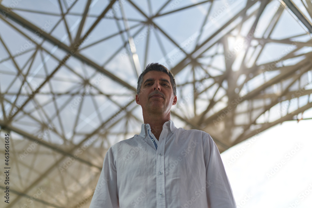 portrait of a person with a metal structure behind him portrait of a person with a metal structure behind him