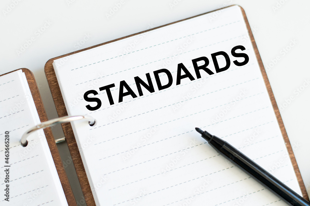 notebook with text Standards On a white background next to a black marker notebook with text Standards On a white background next to a black marker