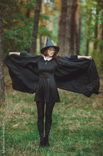 Obraz na płótnie Halloween Witch. Portrait of a girl in a hat and a witch costume in the forest. Ready for trick or treat holiday
w salonie