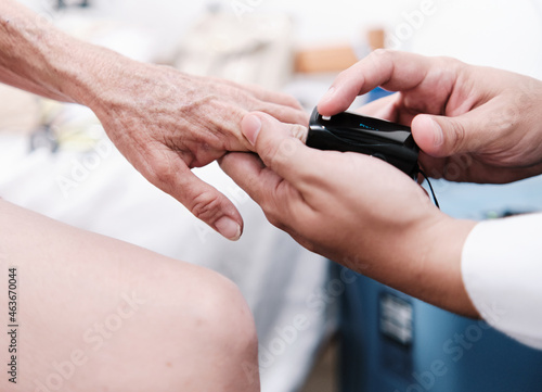 close-up of hands of medical doctor taking saturation in old patient
