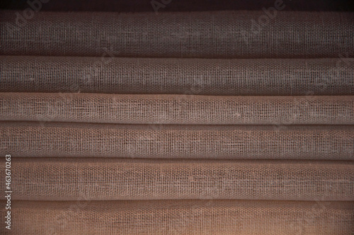 folds of brown curtains. dark background. folded laundry. linear texture.