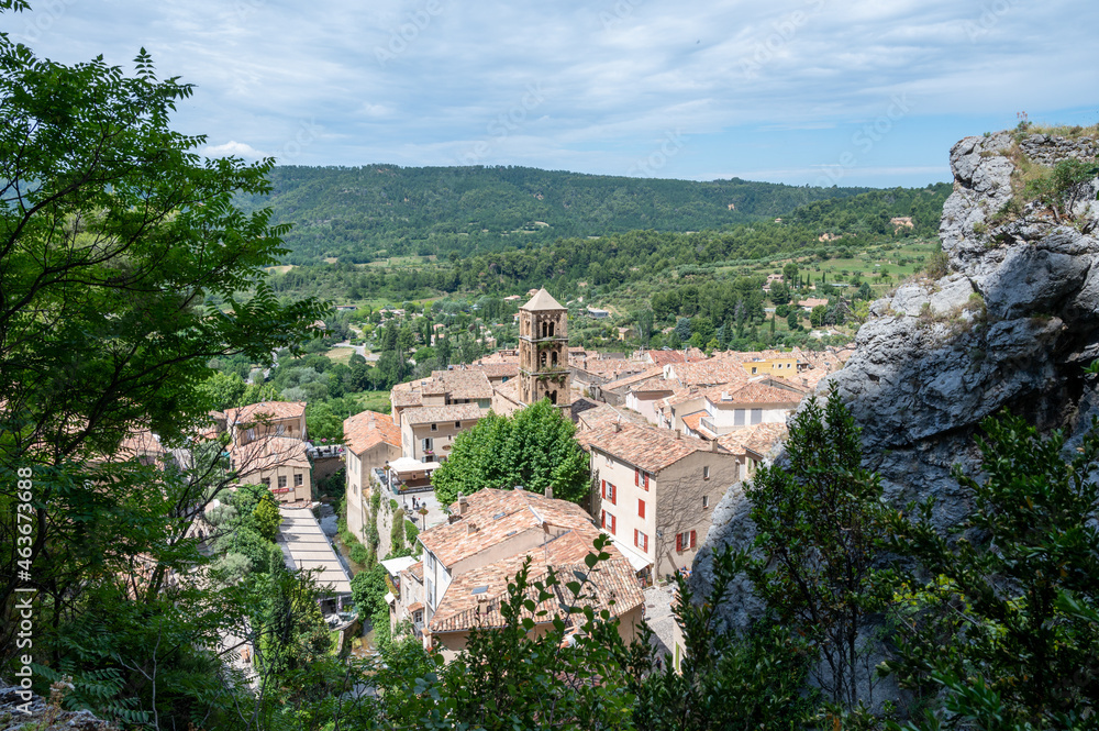 View on mountains cliff, old houses, green valley in remote medieval village Moustiers-Sainte-Marie in Provence, France