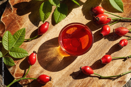 Foto A bowl of rosehip seed oil with fresh rosehips
