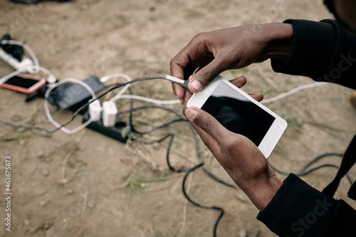 Hand of male migrant hoding smartphone while going to call or record voice message photo