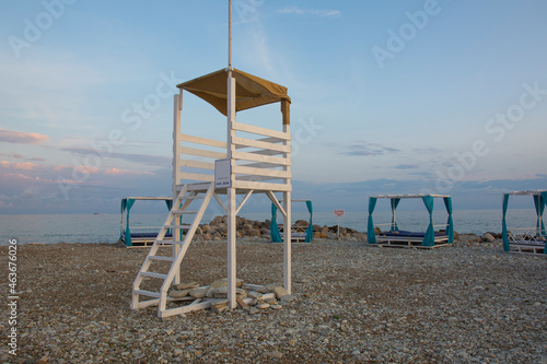 rescue white wooden tower on a pebble beach in the evening sunset