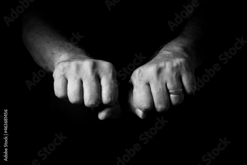 Male hand held out, with clenched fists.