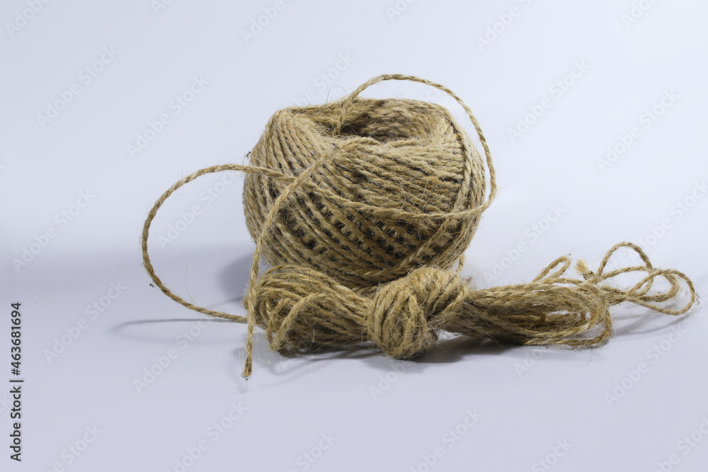 Close-up view of a reel of jute twine or sack rope isolated on a white background. Close-up view of a reel of jute twine or sack rope isolated on a white background.