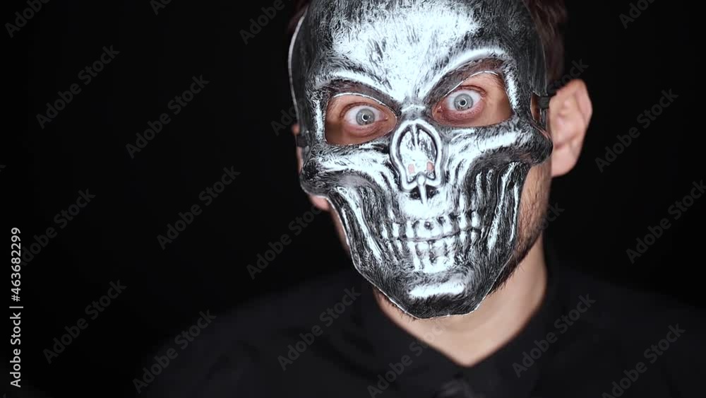 man in a skillet mask looks at the camera with an evil look and shakes his head man in a skillet mask looks at the camera with an evil look and shakes his head