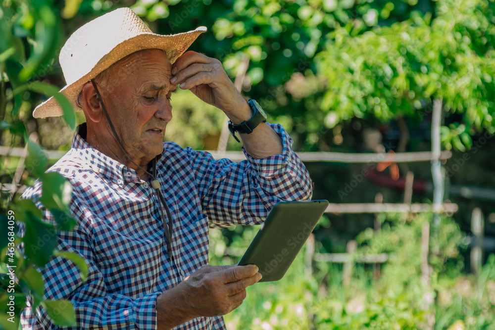 troubled farmer looking at device in field troubled farmer looking at device in field