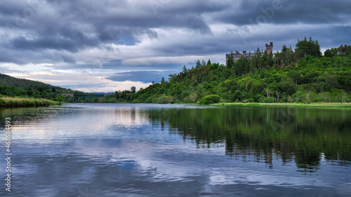 Carbisdale Castle reflected in the calm waters of the Kyle of Sutherland in the Highlands of Scotland photo