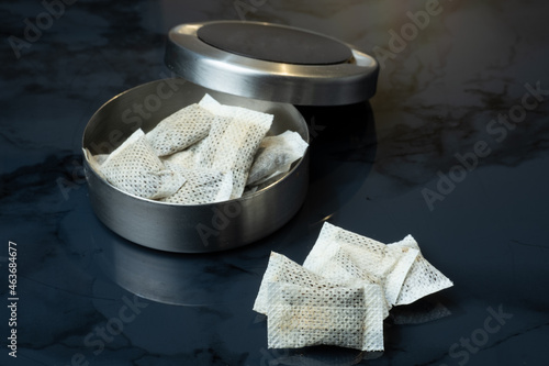 Fototapeta Closeup of a metallic swedish snus can and portion snuff pouches.