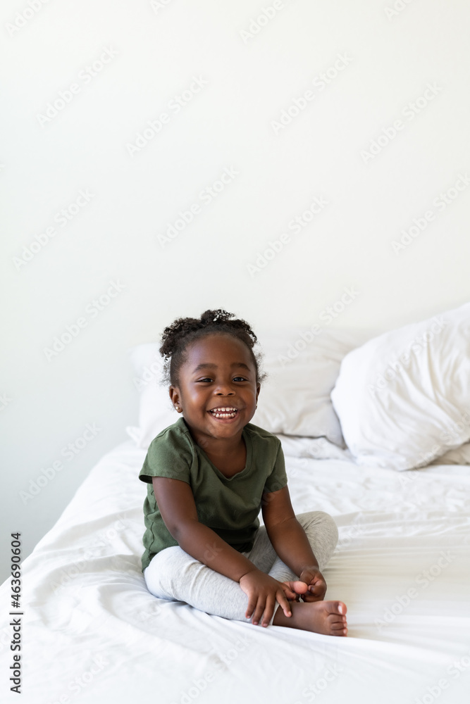 A cute girl sits on a simple bed A cute girl sits on a simple bed