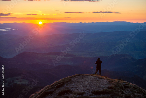 Man in top of mountain photographing the beautiful landscape at sunrise © tutye