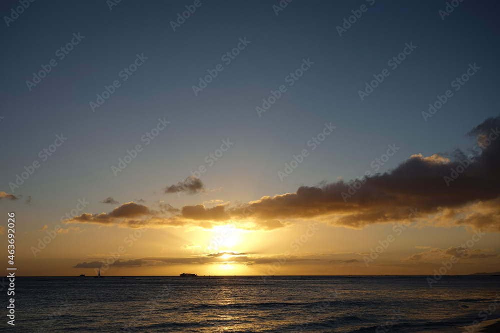 Orange Sunset with purple clouds over a scenic view of the Pacific Ocean off the coast of Waikiki Beach in Hawaii Orange Sunset with purple clouds over a scenic view of the Pacific Ocean off the coast of Waikiki Beach in Hawaii