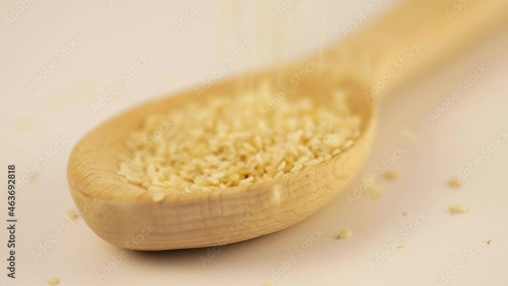 Sesame strewed from above into a wooden scoop Sesame strewed from above into a wooden scoop