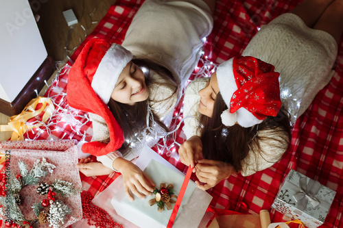 two girls in christmas hats packing christmas gifts