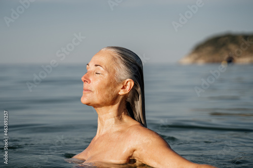 Portrait of beautiful mature woman swimming in the sea photo