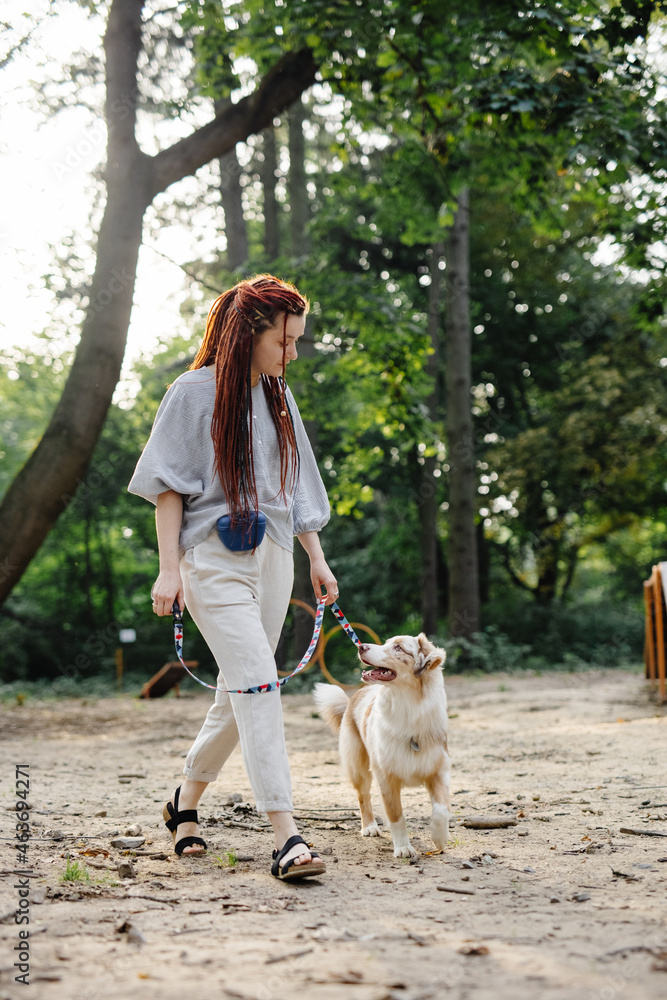 © Oleksii Syrotkin/Stocksy - Female walking dog outside