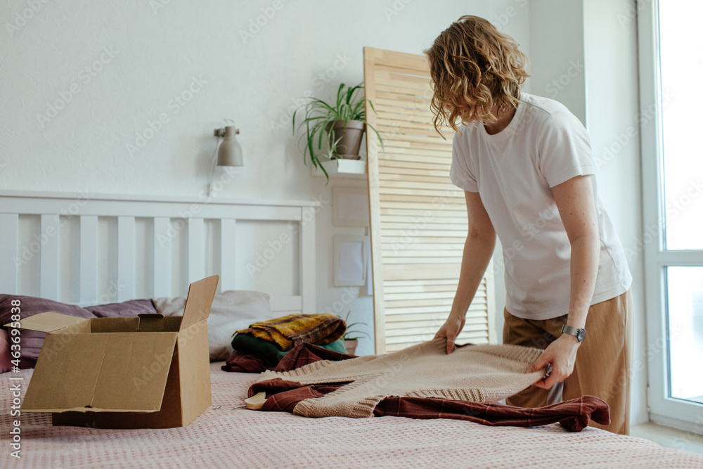 © Sergey Narevskih/Stocksy - Woman packing wear in box © Sergey Narevskih/Stocksy - Woman packing wear in box