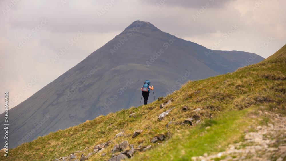Girl hiking up a mountain in the background Girl hiking up a mountain in the background