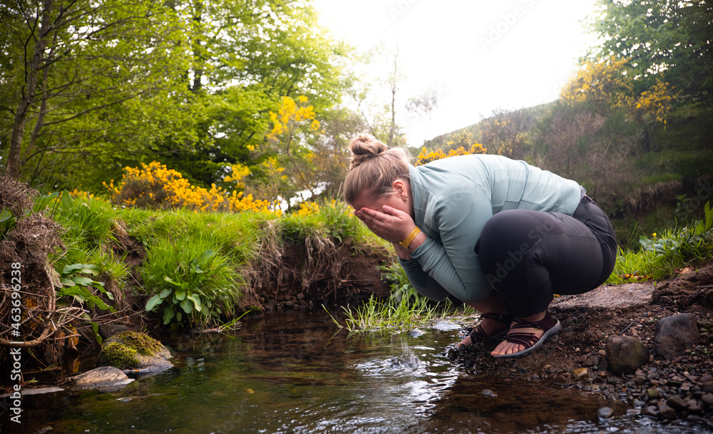 Woman cleaning her face in the river