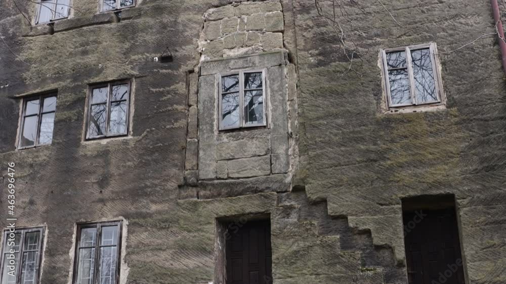 Flower on garden in front of An historical haunted building from stone known as the House of Alchemist, according to folk chronicles a sorcerer lived here, Czech republic.